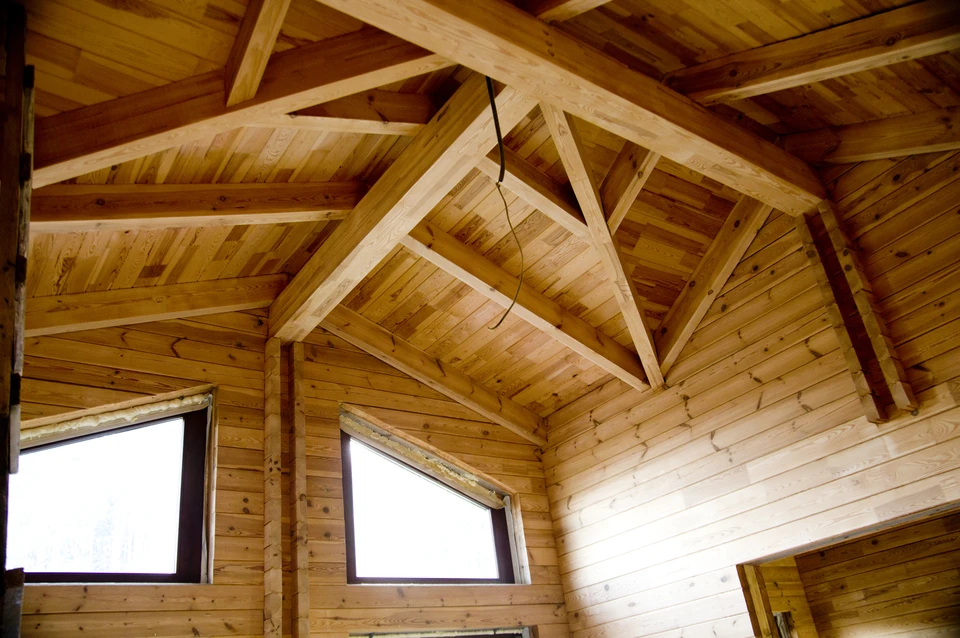 Intérieur d'une construction en bois massif avec charpente apparente