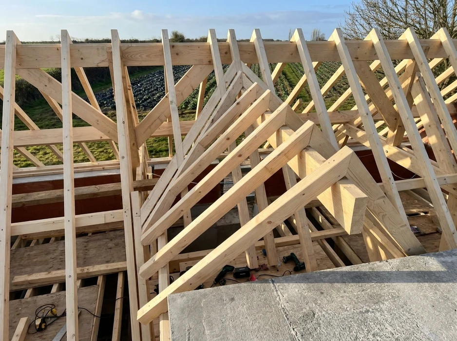 Charpente bois neuve en cours de construction, vue intérieure depuis le sol