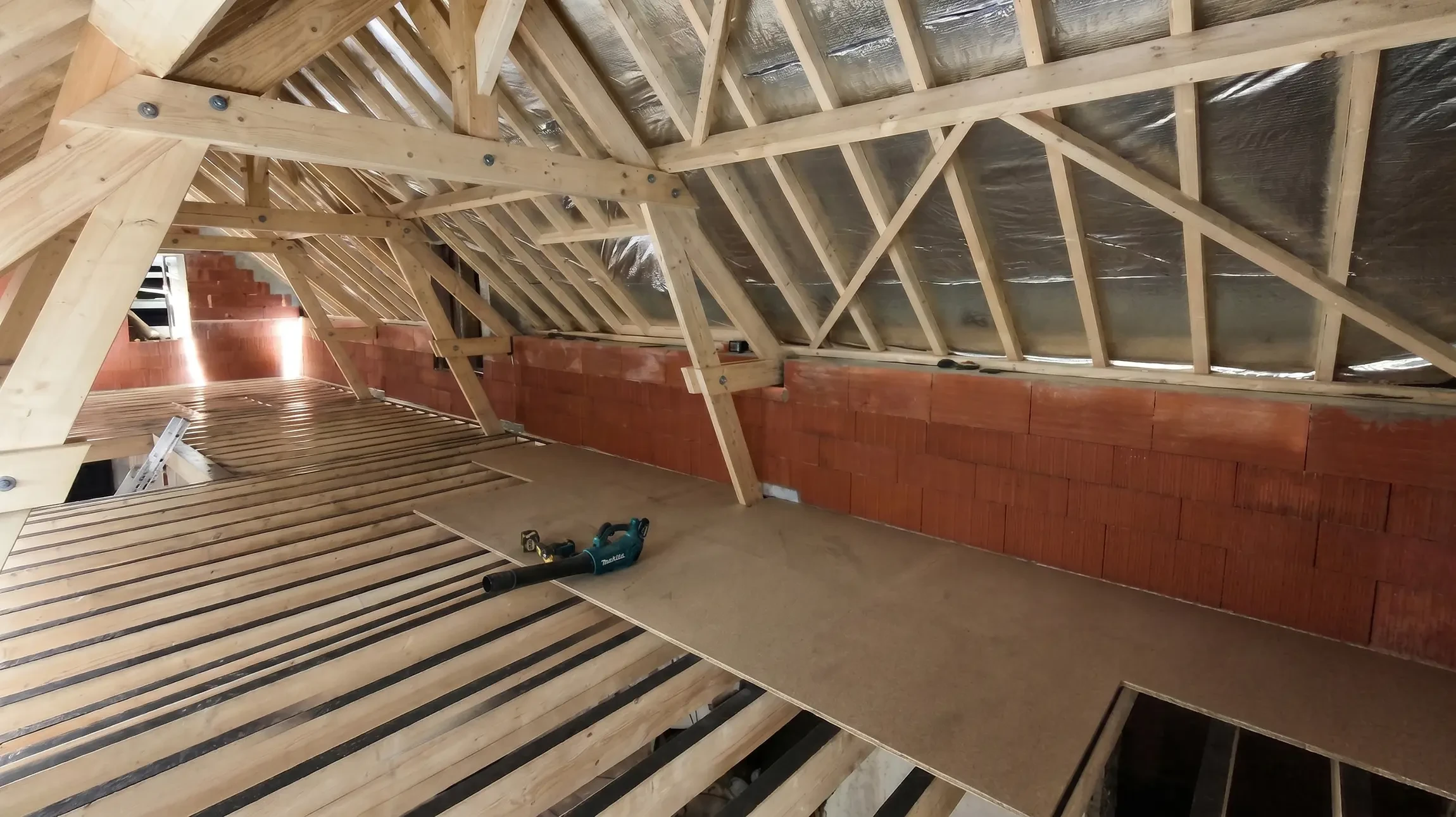 Chantier de construction d'une charpente en bois avec poutres apparentes dans les combles d'une maison